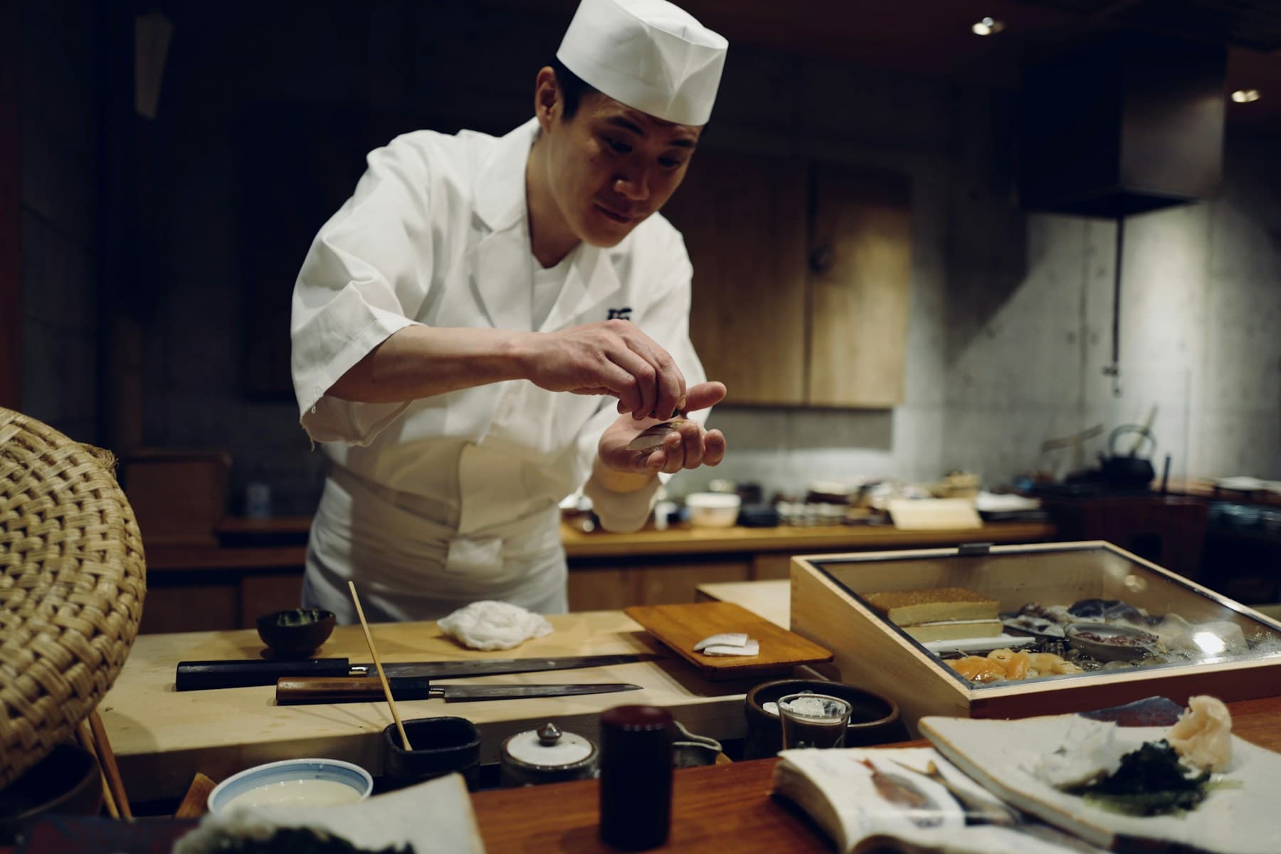 Sushi chef plating at the counter